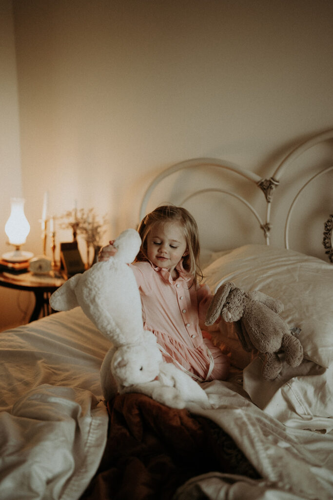 little girl jumping on a bed with stuffed animals | nostalgic motherhood photoshoot